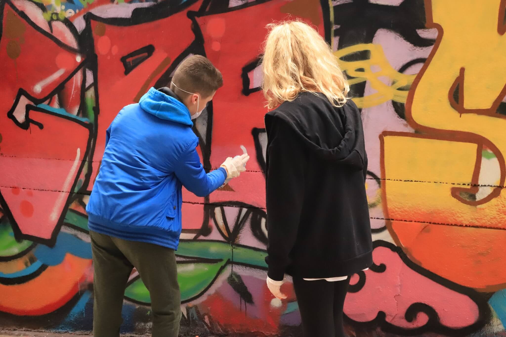 Adolescents qui peignent sur un mur avec une bombe de peinture