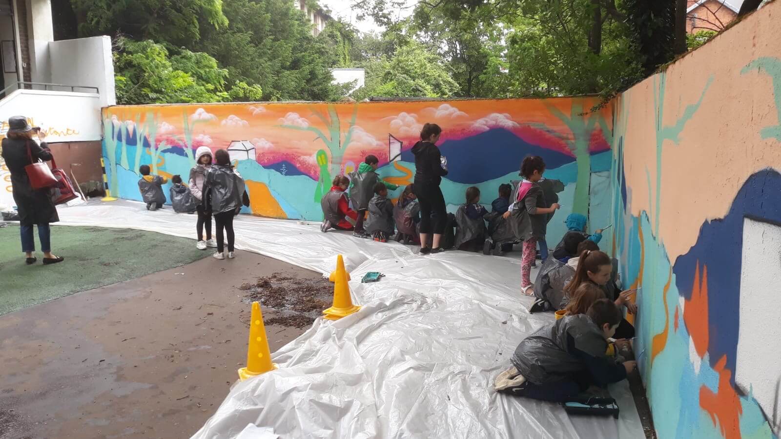Groupe d'enfants qui réalisent une peinture murale